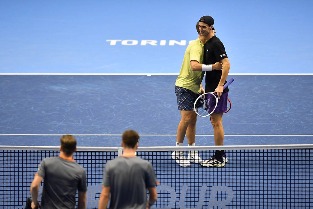 Neal Skupski and Joe Salisbury hug on court after winning a match at the Nitto ATP Finals