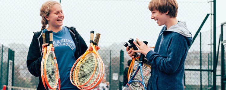 People holding tennis rackets and smiling