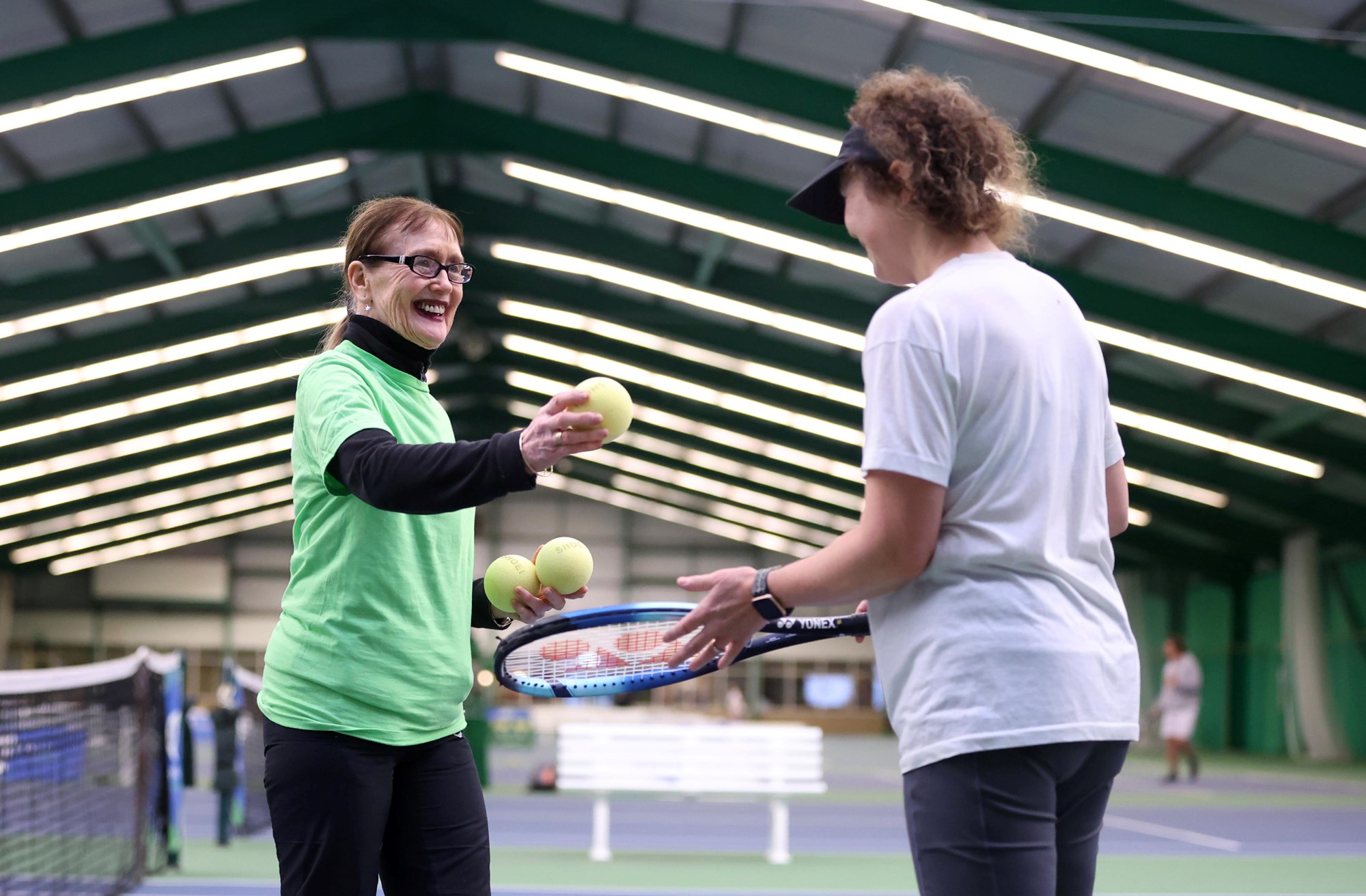 A volunteer interacts with Bethan Jones as she competes during the Visually Impaired Tennis National Finals 2023.