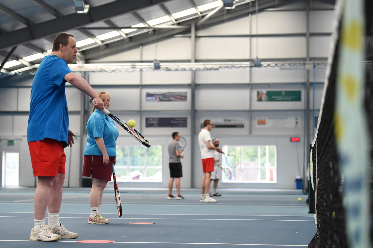 Group of tennis players with a learning disability playing tennis on indoor tennis courts