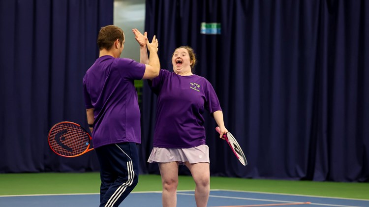 Two players high fiving at the 2025 Learning Disability Tennis National Finals