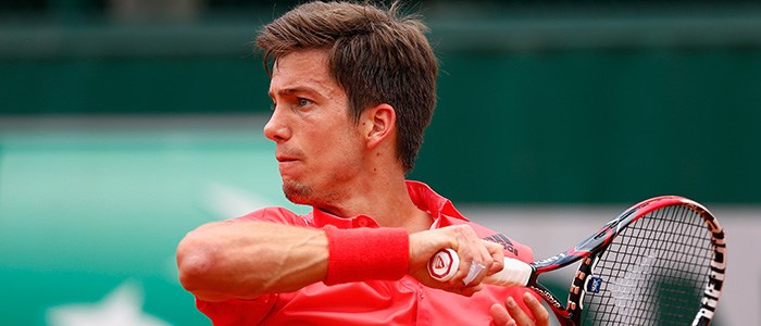 close up of aljaz beden following through with his racket after playing a forehand