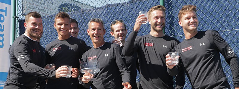 mens players wearing full sleeve black tops with trophies in hand