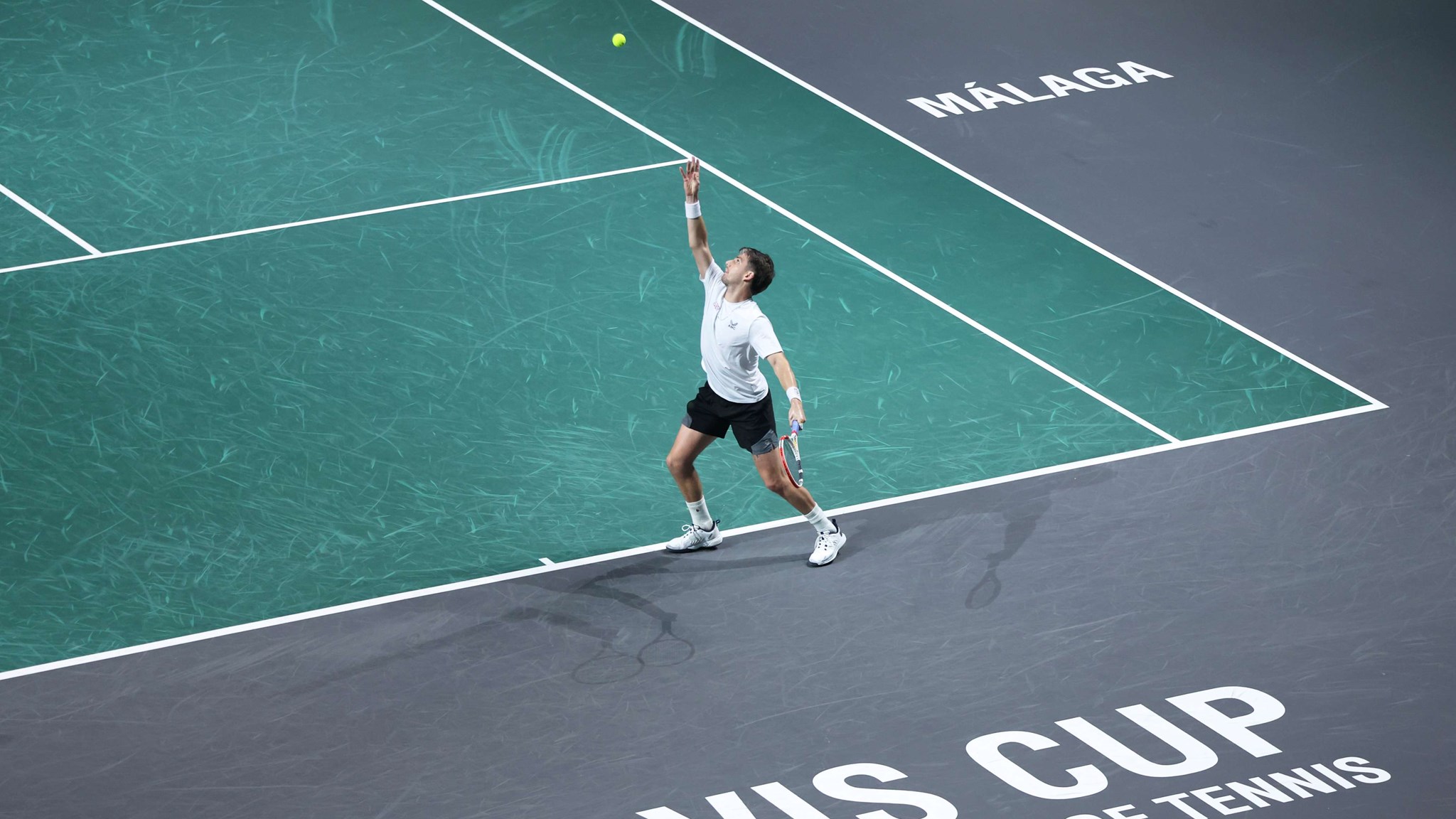 Cam Norrie serving on court, with 'Davis Cup, the world cup of tennis' written on the court