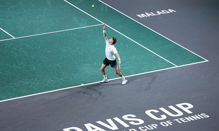 Cam Norrie serving on court, with 'Davis Cup, the world cup of tennis' written on the court