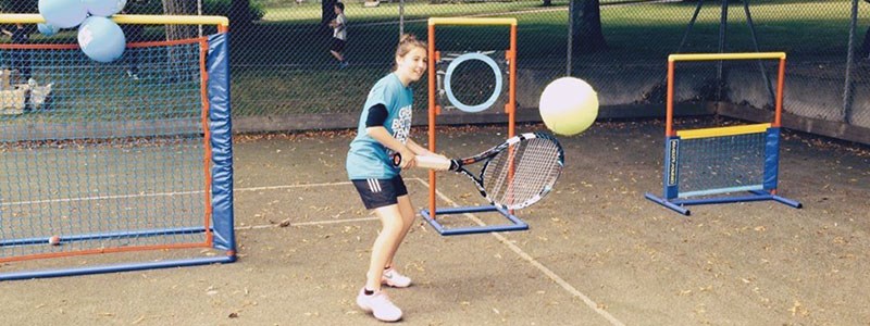 Roxanne Marshall hitting a backhand with a large racket and ball