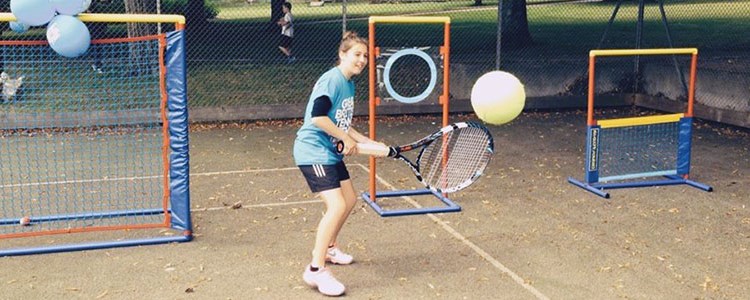 Roxanne Marshall hitting a backhand with a large racket and ball