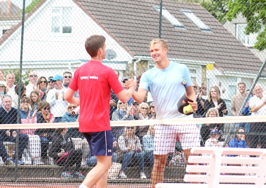 Two players shake hands at the net