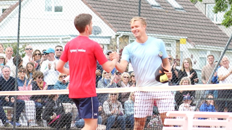 Two players shake hands at the net