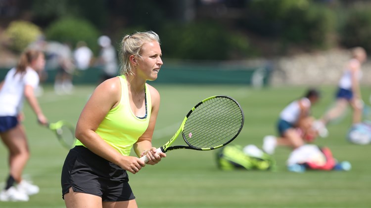 Woman holding tennis racket on 