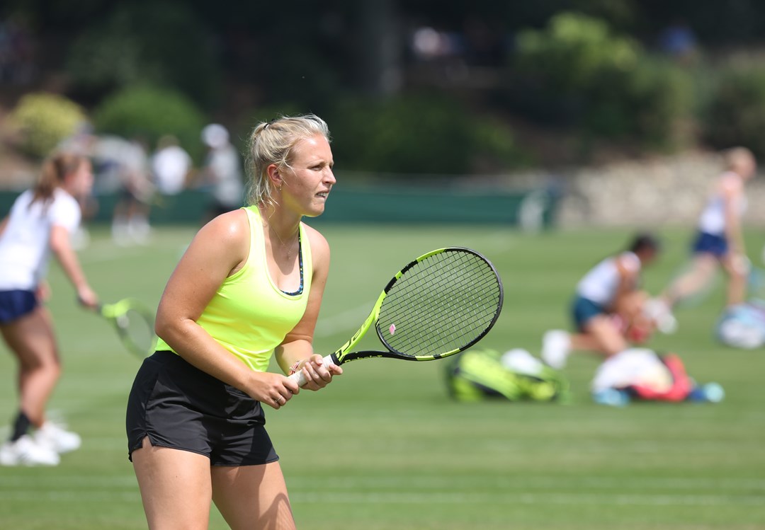 Woman holding tennis racket on 