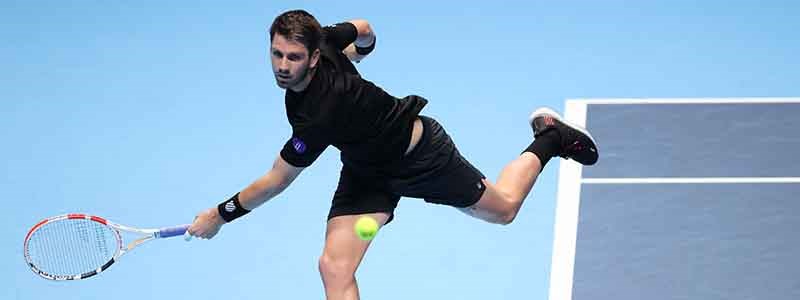 cam norrie on court reaching out to play a backhand