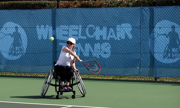 Junior wheelchair tennis player in action about to take a shot