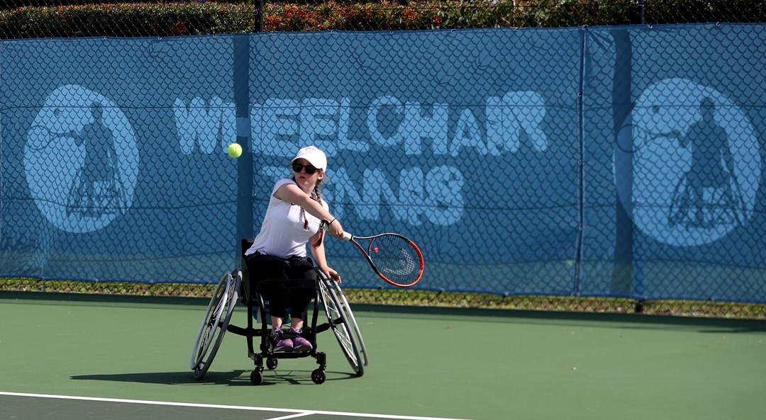 Junior wheelchair tennis player in action about to take a shot