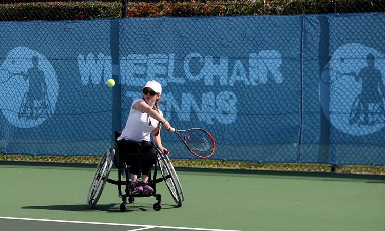 Junior wheelchair tennis player in action about to take a shot