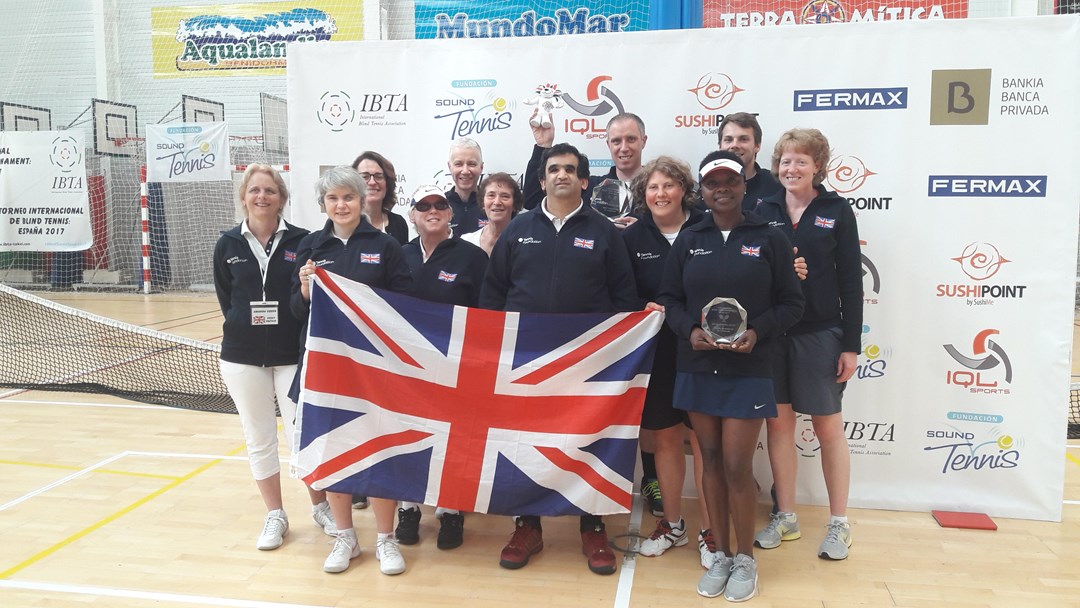 International Blind Tennis Tournament GB Team posing behind large union jack flag