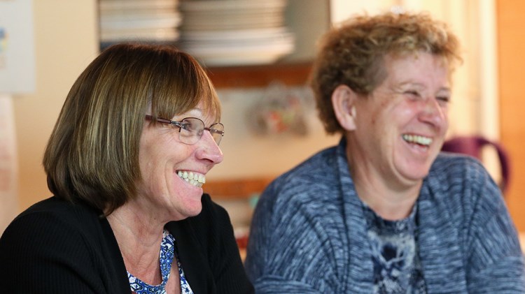 close up or caroline ratcliffe smiling sitting next to other committee member