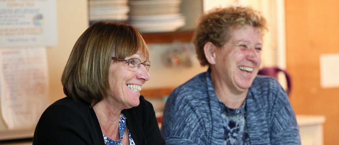 close up or caroline ratcliffe smiling sitting next to other committee member