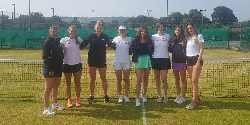 Group of girls side by side, together on a tennis court