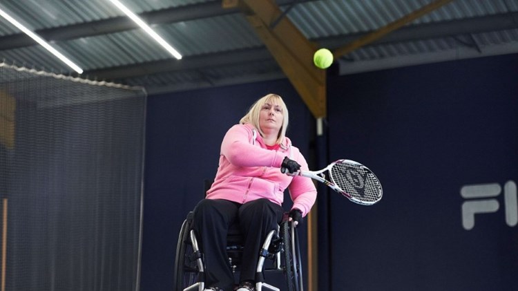 Female wheelchair player about to take backhand shot