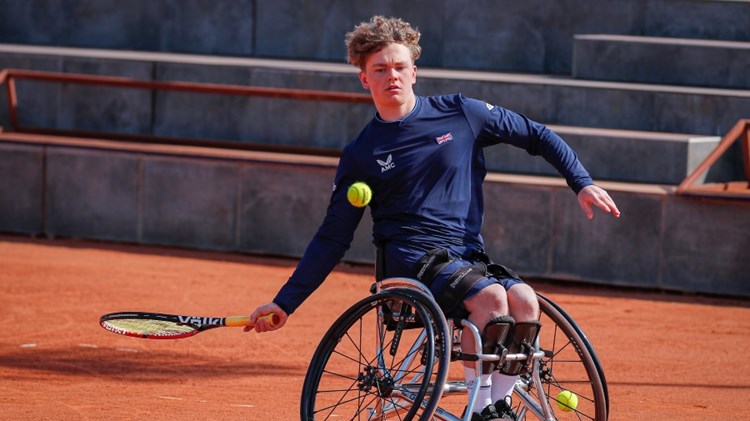 Male handicapped tennis player hitting a ball