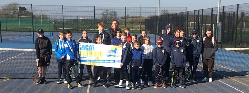group of youth and coach standing on court at Cheslyn Hay tennis club holding a Team Challenge sign