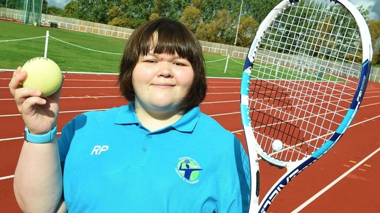 rosie pybus holding a tennis ball and racket on court