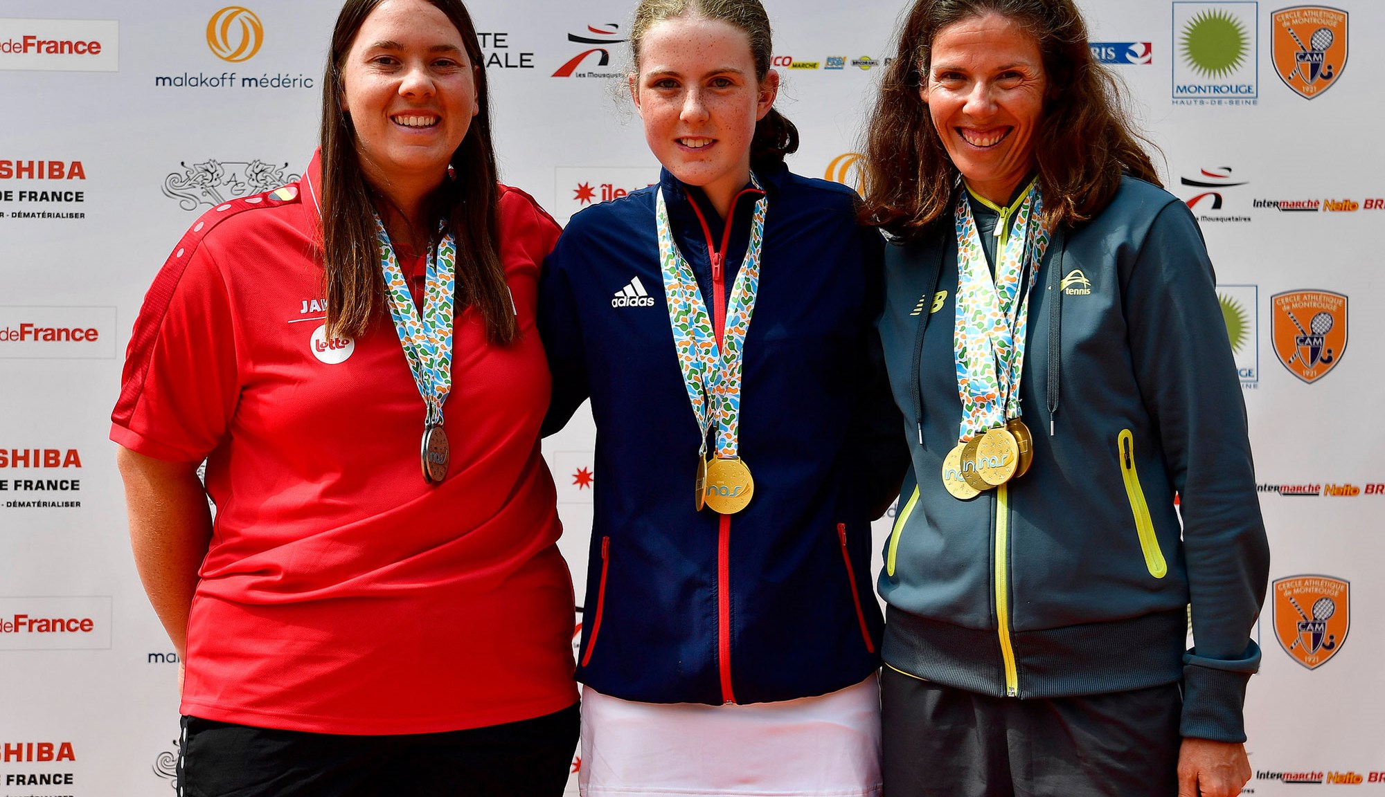 Anna Mcbride wearing her medal posing with two other players