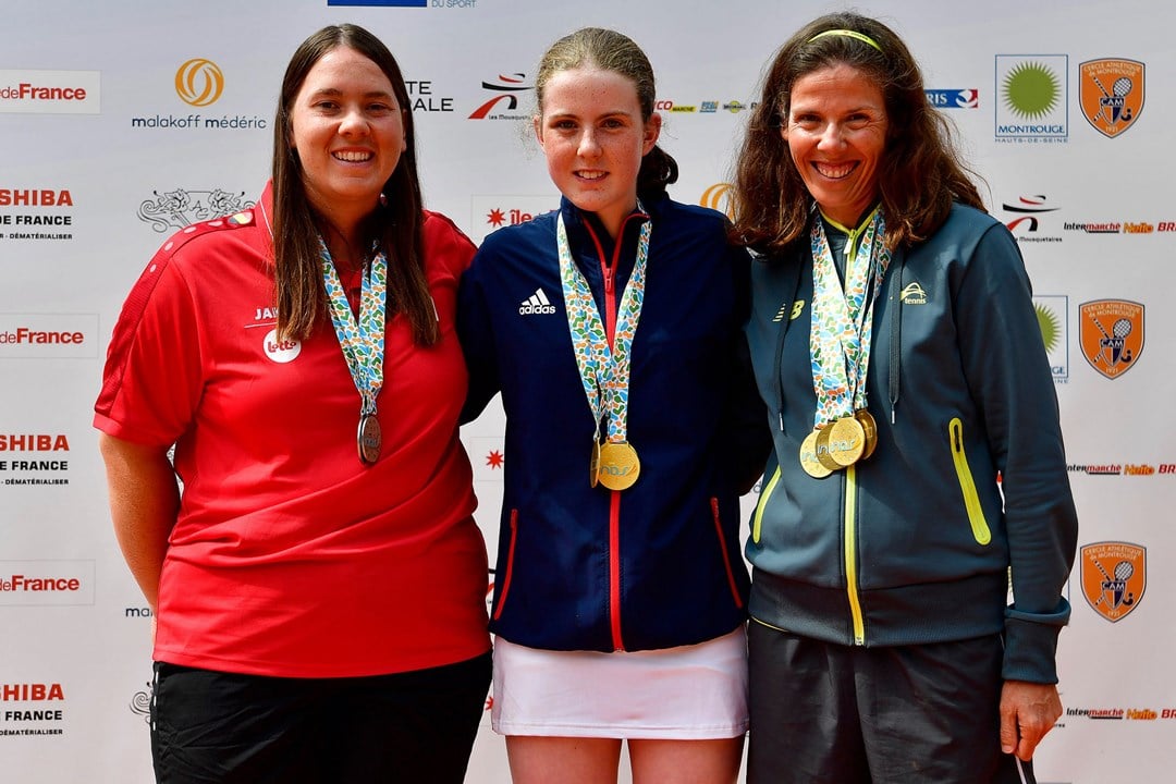 Anna Mcbride wearing her medal posing with two other players