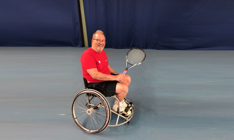 Steve Dargavel smiling and holding tennis racket