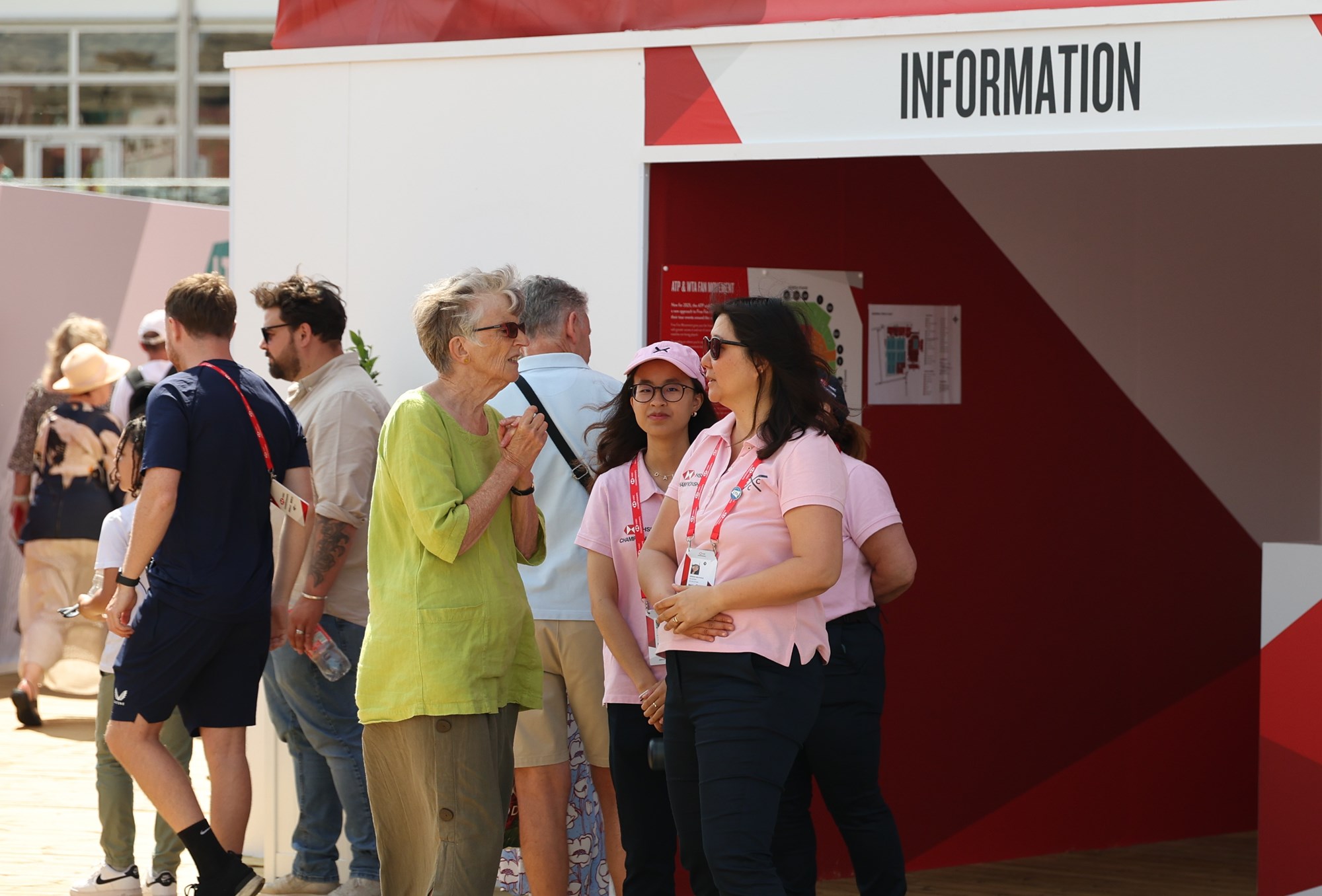 A volunteer at HSBC Championships chatting to an attendee in front of the stands