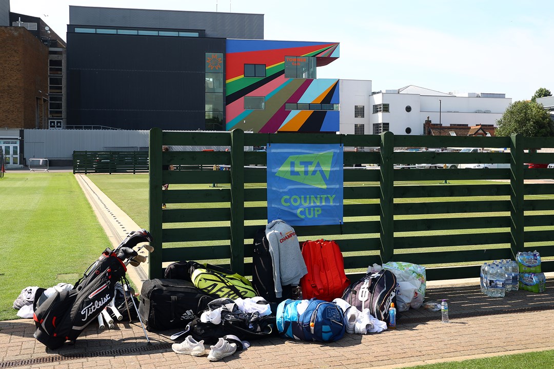 Kit bags against fence with LTA County Cup logo
