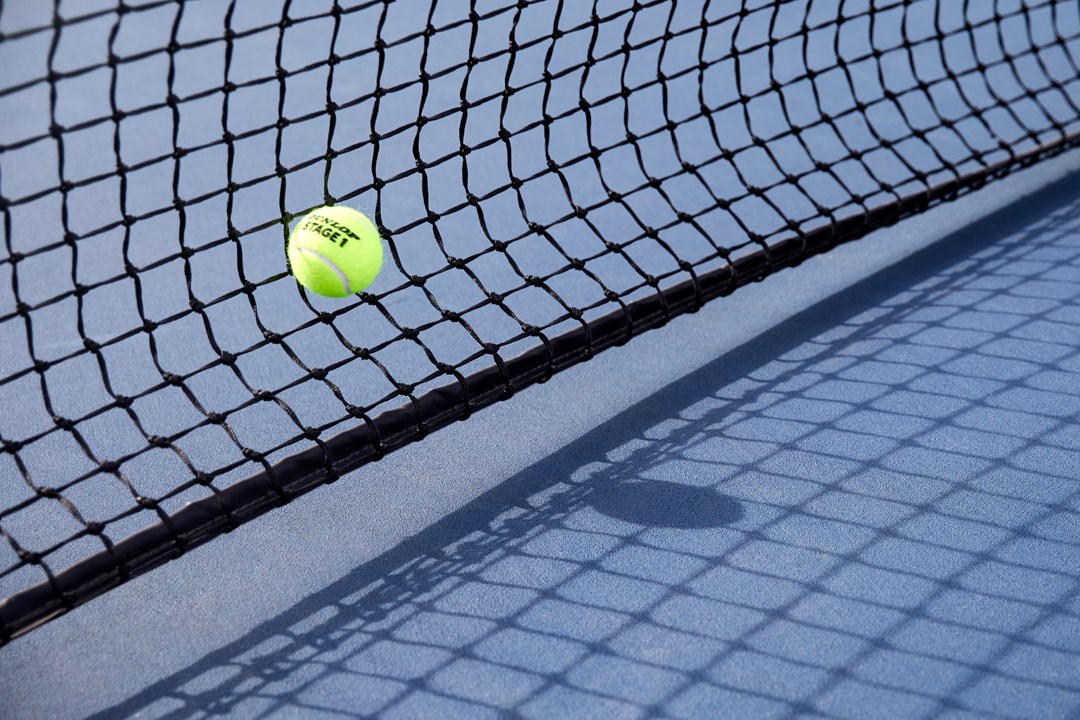 Close up of tennis ball hitting net