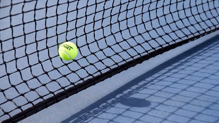 Close up of tennis ball hitting net