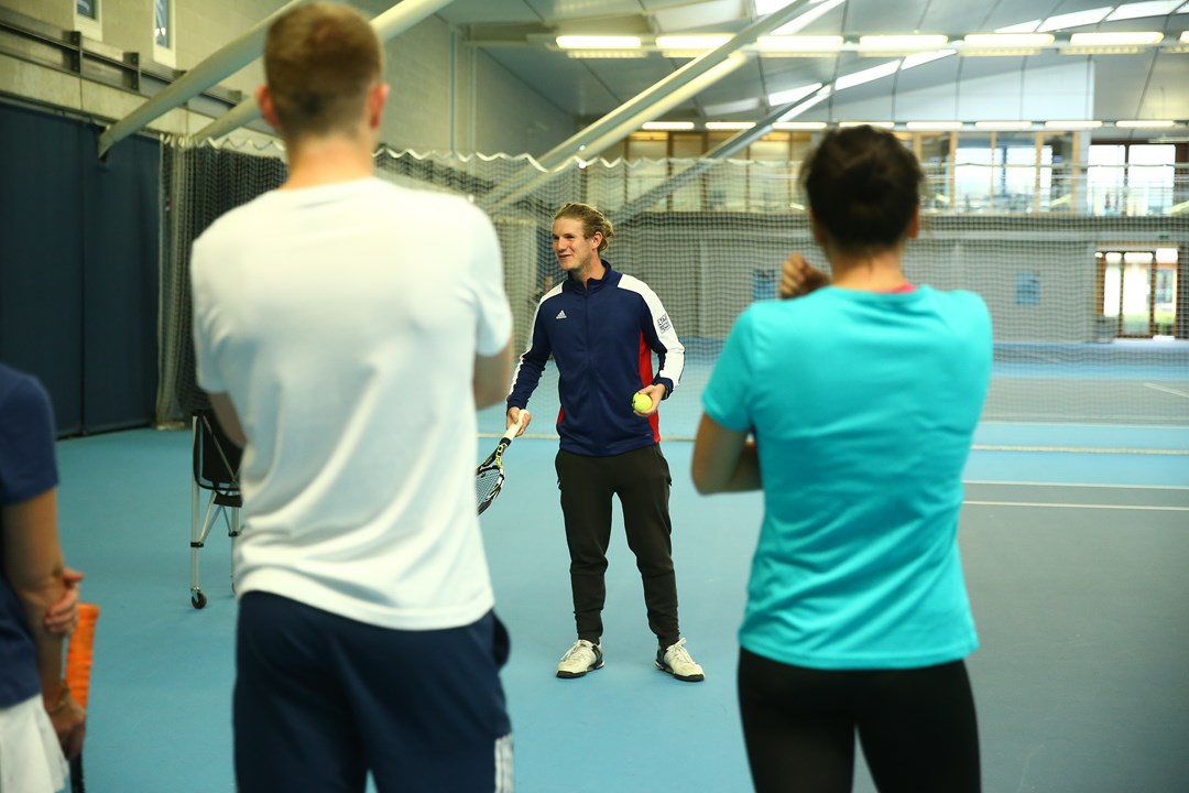 Tennis coach speaking to players