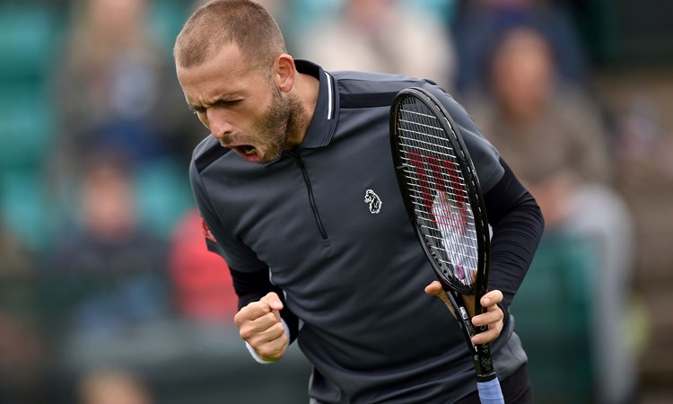 Dan Evans shouting with a racket in hand