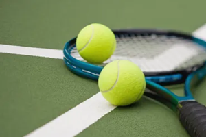 tennis balls laying on the floor next to a tennis racket