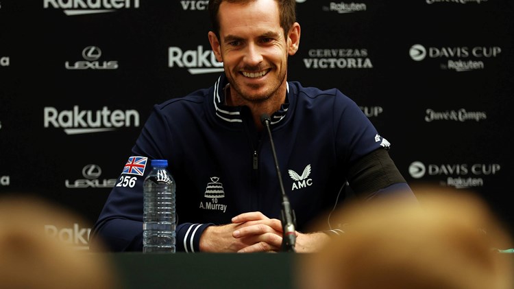 A man smiling in front of a mic