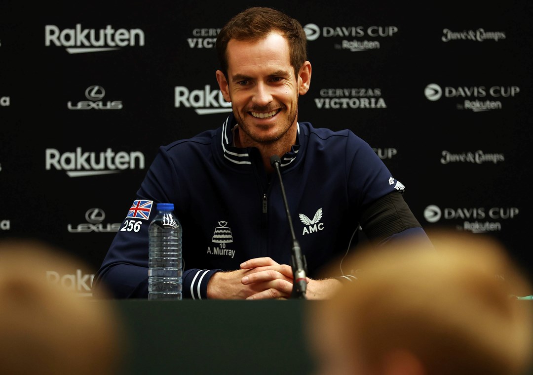 A man smiling in front of a mic