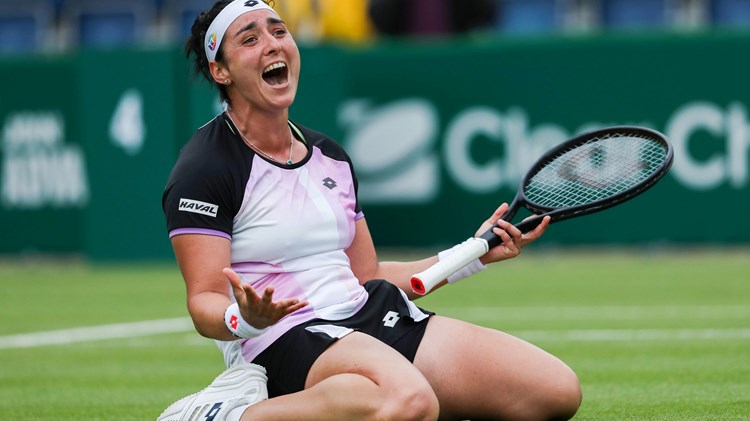Female tennis player celebrating on her knees