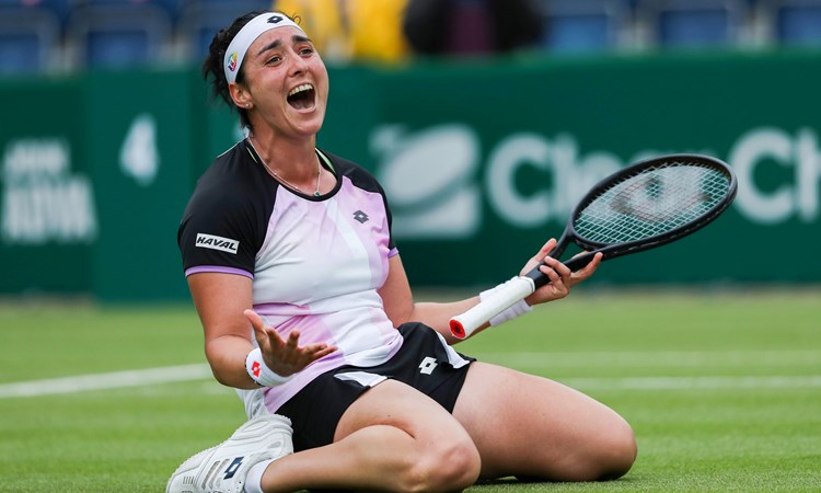 Female tennis player celebrating on her knees