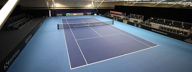 A full shot of an empty blue tennis court