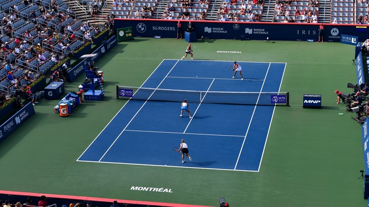 Female doubles match on a hard tennis court