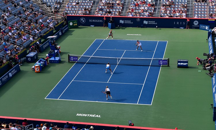 Female doubles match on a hard tennis court