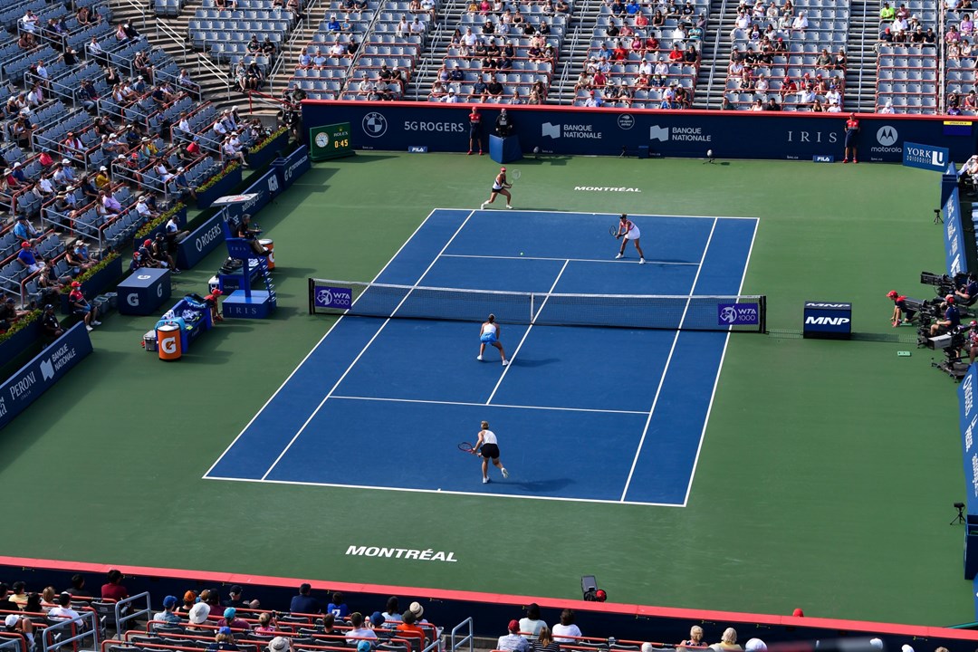 Female doubles match on a hard tennis court