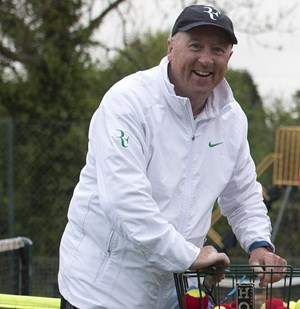Chris Hill smiling as he cleans up tennis balls