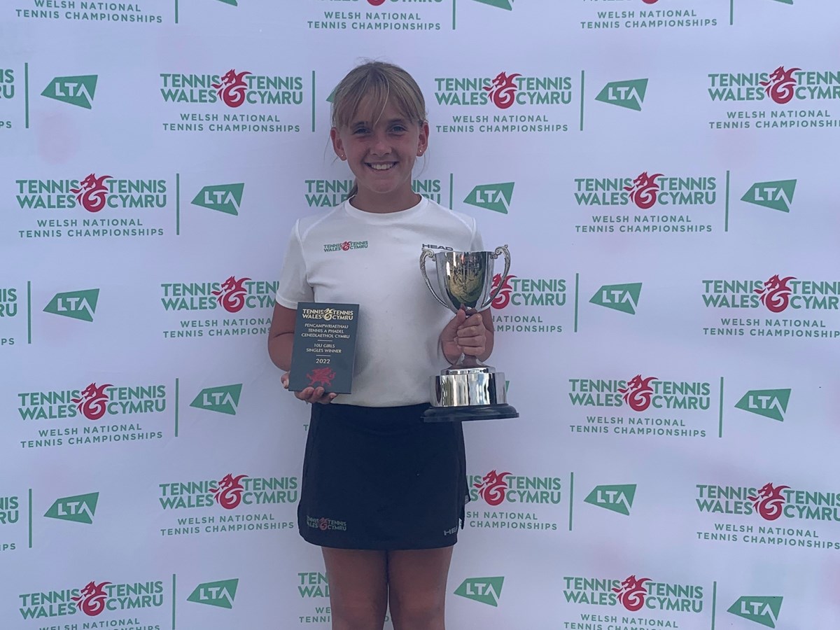 Female tennis champion holding her trophy 