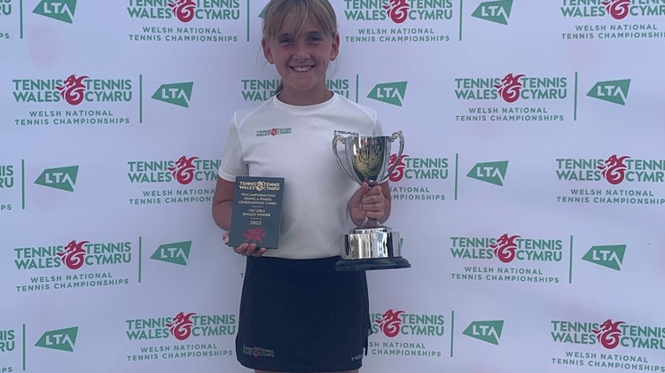 Female tennis champion holding her trophy 