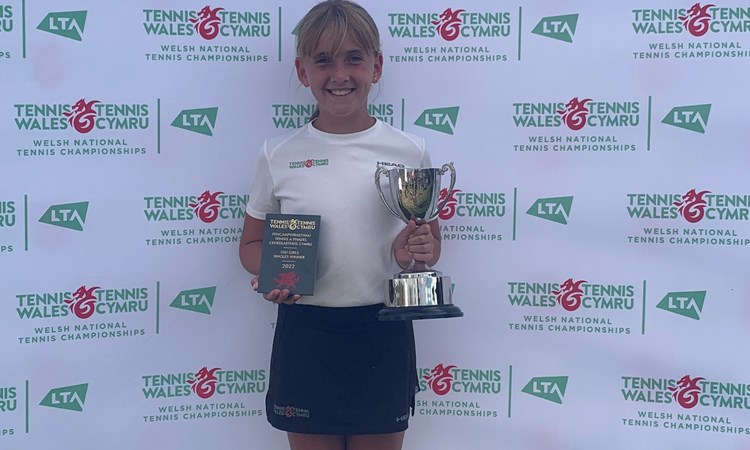 Female tennis champion holding her trophy 