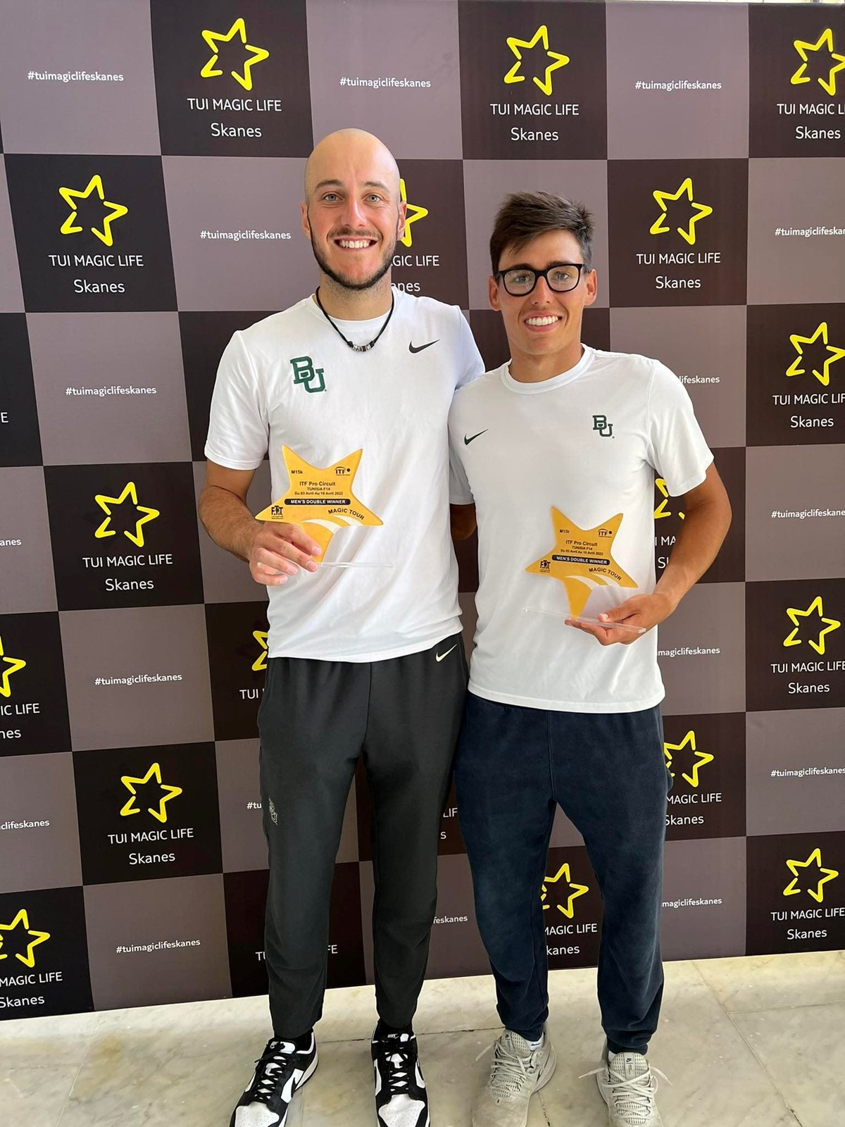 two males standing with awards in their hands